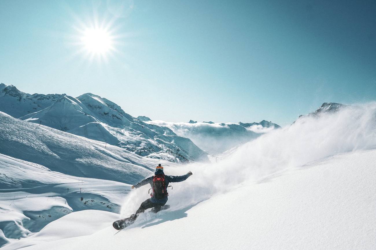 Snowboarder descending a steep powder face